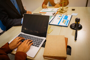 Two male and female lawyers sit at a table in an office, discussing legal matters related to opening a company.They focus on laws, regulations,and collaboration between in-house and business lawyers