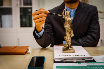 Two male and female lawyers sit at a table in an office, discussing legal matters related to...