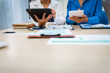 Fototapeta premium Close-up of three business people's hands during a meeting at an office table.They are engaged in discussions,planning,analyzing finance, investments, and market trends during a monthly team meeting