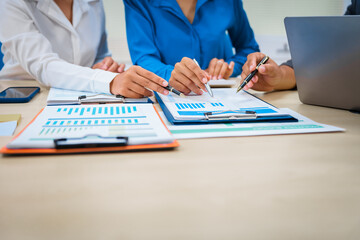 Close-up of three business people's hands during a meeting at an office table.They are engaged in discussions,planning,analyzing finance, investments, and market trends during a monthly team meeting