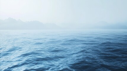 Calm, serene water landscape with foggy backdrop.