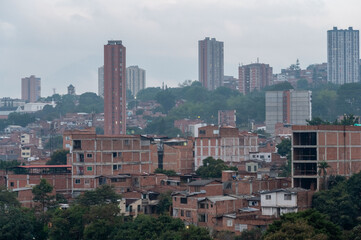 A cityscape blending modern high-rises with densely packed residential buildings. A mix of urban...