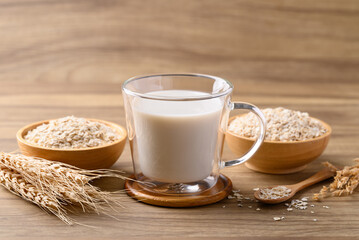 Oat milk in cup glass on wooden background, Alternative milk made from plant, non dairy