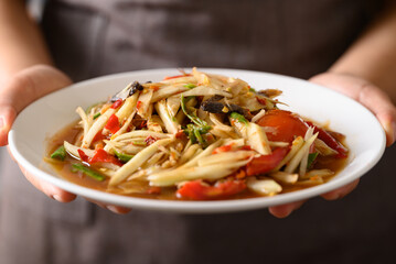 Spicy papaya salad (Som Tum) with hand, Local Thai food