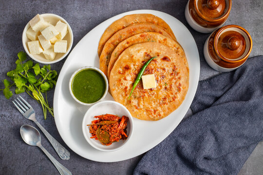 Paneer ka paratha is a delicious Indian flatbread stuffed with spiced paneer, served hot with chutney, curd, or pickle.