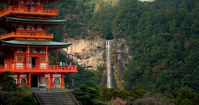 Majestic Nachi waterfall in Japan framed by red painted temple pagoda