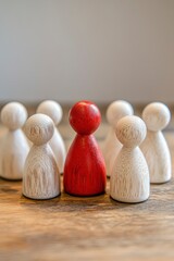 a leader in business development concept, A red wooden figurine stands out among the white ones on an office table