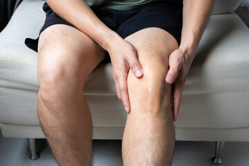 Man with knee pain, he puts his hand on his knee, pain point from osteoarthritis and...