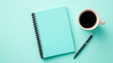 Minimalist Workspace Setup Featuring a Turquoise Notebook, Black Pen, and Coffee Mug on a Soft Blue Background Ideal for Creative Inspiration and Planning