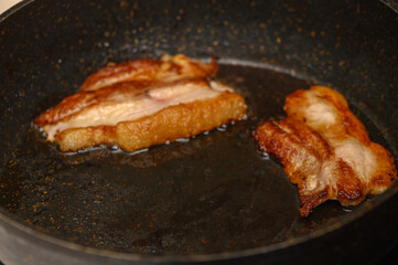 Sizzling strips of bacon cooking in a hot skillet during a cozy morning breakfast