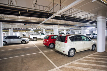 underground concrete parking with sedan cars, bakkie and small truck in the basement,