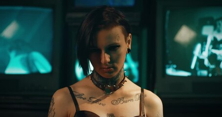 Aggressive young woman with tattoos and piercings looking at camera, portrait. Subculture of gothic and rock, alternative style, alt woman, self-expression by appearance, deviant behavior of youth