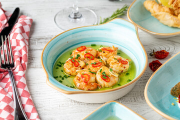 Appetizer with shrimps, onions and tomatoes on a white porcelain plate