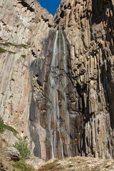 Foaming water falls from great height against backdrop of unique mountain range. Famous Abai-Su waterfall is two streams flying down steep cliff 72 m high. Kabardino-Balkaria. Chegemsky Reserve 2024.