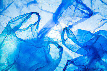 plastic waste, background, blue disposable plastic shopping bags lying around, crumpled structure