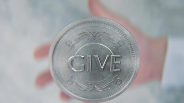 A hand flips a coin marked Take and Give, spinning toward the camera in slow motion