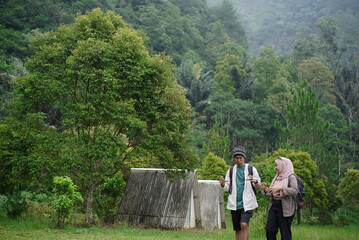 Young Indonesian female travelers wearing hijab and Indonesian male travelers enjoying a trip in nature, travel concept.