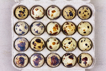 Obraz premium an open paper tray with quail eggs on a gray background top view