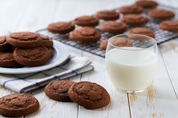 Fototapeta premium Tasty chocolate cookies and glass milk on a light kitchen table, selective focus.