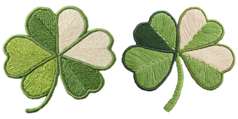 Two embroidered shamrocks in varying shades of green, showcasing intricate detailing and a natural look.