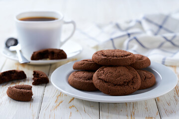 Tasty chocolate cookies and coffee on a white table, selective focus.