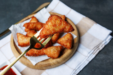 chicken nuggets with red sauce, ketchup, on a dark background with a white kitchen towel, fast food, snack