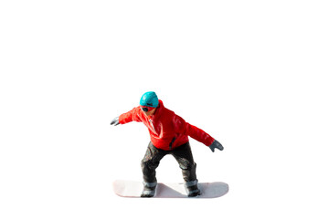 Miniature figurine depicting a snowboarder in mid-motion isolate on white background with clipping...