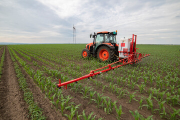 Tractor spraying pesticides at corn fields