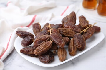 Tasty dried dates on white marble table