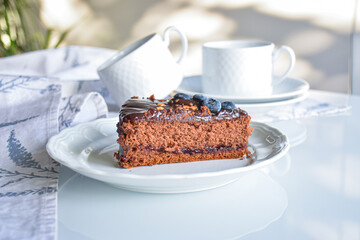 chocolate sacher cake decorated for party. neutral white background with kitchen elements. homemade...