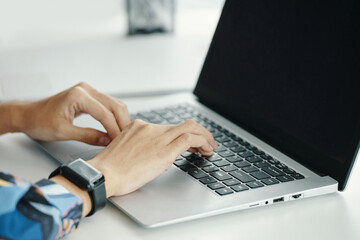 Closeup of unrecognizable female managers hands typing on laptop at workplace in modern office