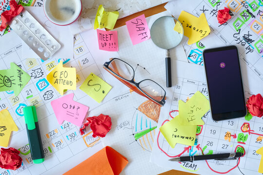 Calendars with business appointments and adhesive notes on cluttered desk. Business concept,beat the clock,overwoked,bureaucracy