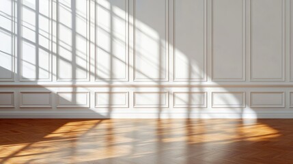 Fototapeta premium A bright, spacious room with wooden flooring and elegant wall design, showcasing long shadows from sunlight filtering through windows.
