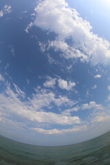 wide-angle view of the sky and the sea below with a bubble effect caused by the fisheye lens
