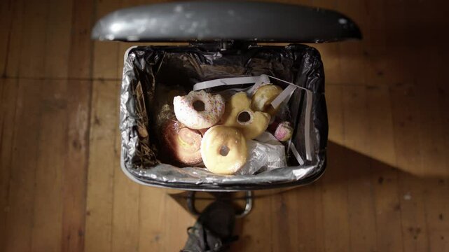 POV of dumping leftover junkfood and candies into bin for new year's resolution