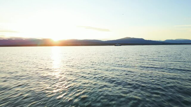 Push in drone shot of boat sailing on Lake Geneva at sunrise in Switzerland