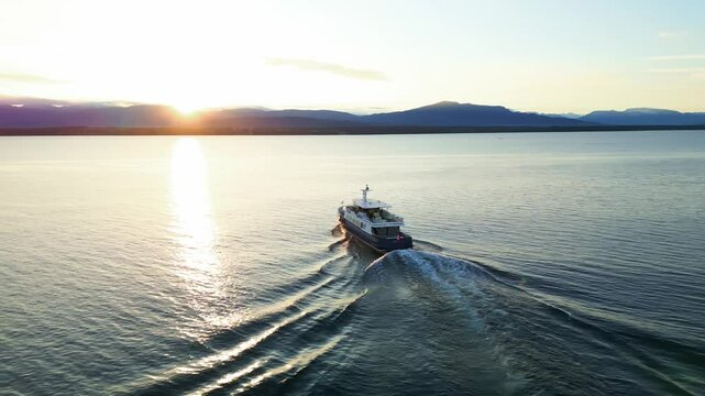 Parallax drone shot of boat sailing on Lake Geneva at sunrise in Switzerland