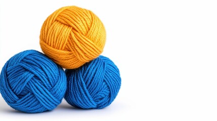 Three vibrant yarn balls in blue and yellow, stacked playfully, perfect for crafting and knitting projects.