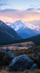Fototapeta premium Snow-capped Mountain Range at Dawn with a Single Boulder in the Foreground