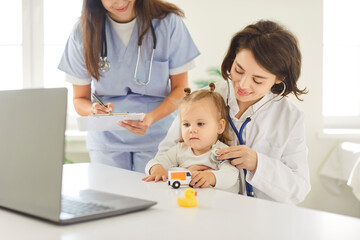 Doctor pediatrician and nurse check a baby breathing and lungs during a healthcare appointment...