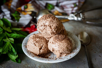 Homemade chocolate ice cream on a white plate on a gray background. Balls of chocolate ice cream for dessert . Close-up