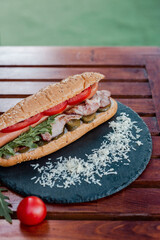 hot dog with sausage, tomato and pickled cucumber