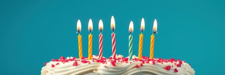 Seven colorful candles on a birthday cake burning brightly against a blue background