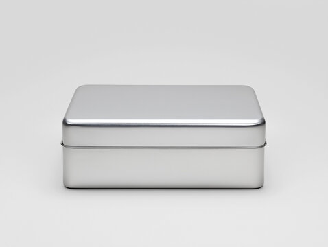 Shut Tin Box Tipped Modestly on Sleek Silver Background, Highlighting Minimalist Design
