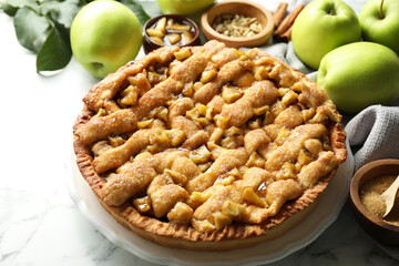Homemade apple pie and ingredients on white marble table