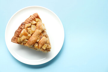 Slice of homemade apple pie on light blue background, top view. Space for text