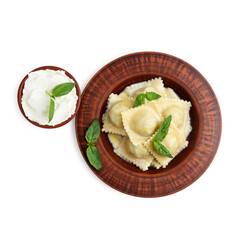 Delicious ravioli with cheese and basil in bowl isolated on white, top view