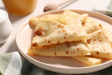 Delicious folded crepes on table, closeup view
