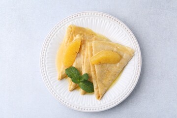 Delicious Crepes Suzette on light table, top view