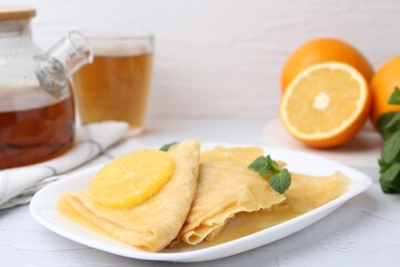 Delicious Crepes Suzette served on white textured table, closeup